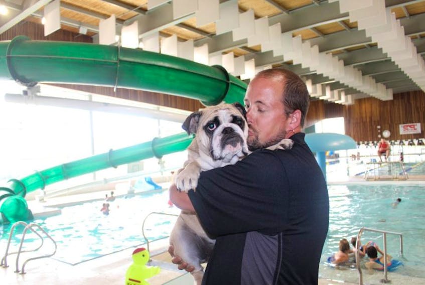 <p>Sean Murphy gives his one-year-old bulldog, Guinness, a kiss. Murphy is organizing a doggie swim night for Sept. 5, at the Credit Union Place, Summerside.&nbsp;</p>