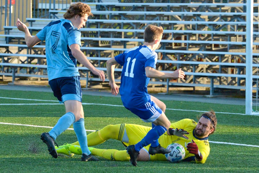 Feildians goalkeeper Braedon Sheppard makes a save as teammate Iain Gamba (7) and the St. Lawrence Laurentians' Cabhan O’Keefe (11) look on during Challenge Cup soccer action at King George V Park Saturday evening. — Keith Gosse/The Telegram