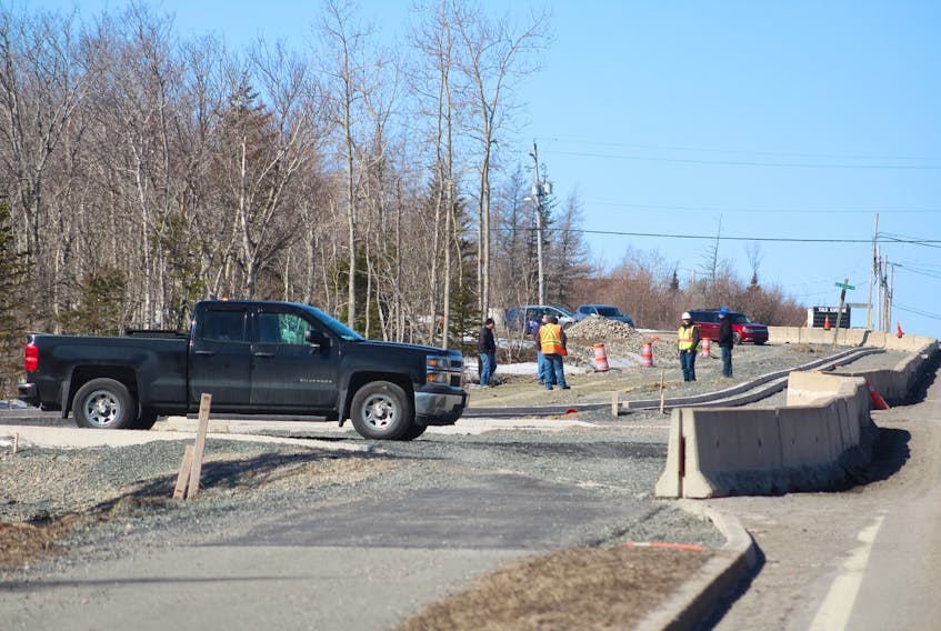 Two Department of Transportation and Infrastructure workers speak with contractors on April 9 at the Donkin mine haul road intersection near Grand Lake Road. With production stopped at the mine, there is no coal to be hauled and the road is no longer needed. NICOLE SULLIVAN/CAPE BRETON POST 
