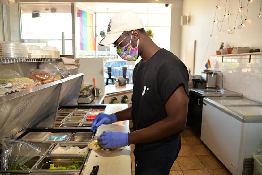 Joshua Obembe makes a wrap on Thursday at Juice Co.'s downtown Charlottetown location. The business is one of many that has seen lower revenue this summer as a result of more people working from home. 