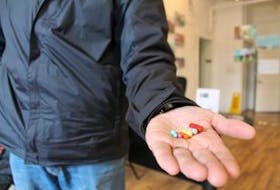 ['A member of the Prince District JFO Drug Unit holds empty capsules of the drug hydromorphone, one of the unit’s biggest problems in prescription drug abuse.']