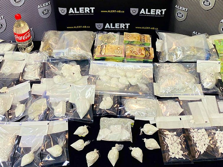 Photo of a table of drugs and cash seized in Project Incumbent, an ALERT investigation that dismantled a drug network in Grande Prairie, Alta. Supplied image/ALERT
