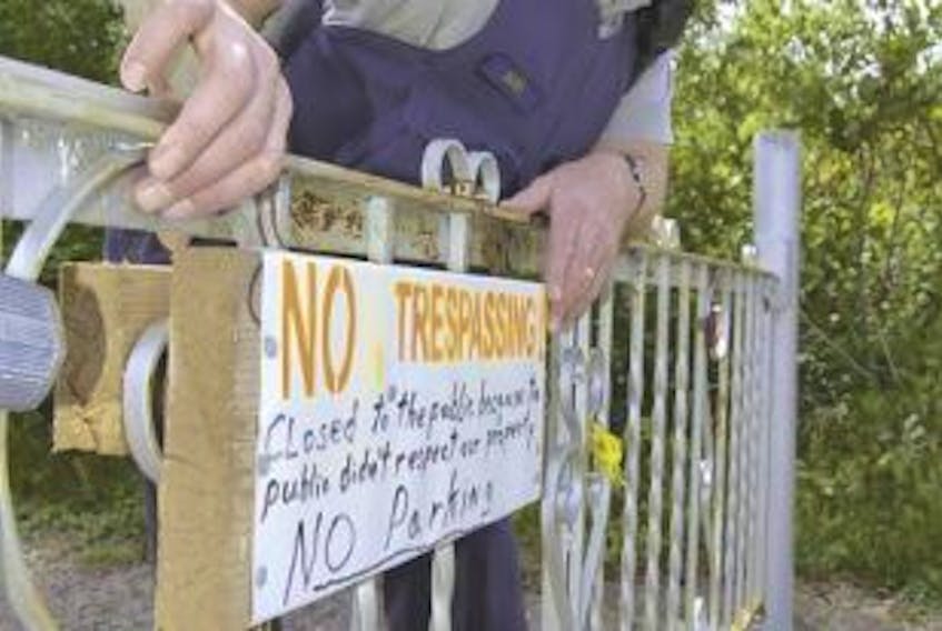 ['RCMP Cpl. Jim Baird reads a No Trespassing sign posted on a locked gate blocking entry to Drysdale Falls near Tatamagouche. Access to the popular 30-metre high falls is now strictly prohibited by the propertys owners and will be\nenforced by police. Sherry Martell - Truro Daily News']