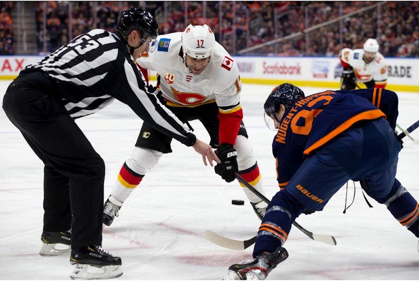 The Edmonton Oilers' Ryan Nugent-Hopkins takes a face-off against the Calgary Flames' Milan Lucic during first-period NHL action at Rogers Place, in Edmonton Friday. Photo by David Bloom/Postmedia.
