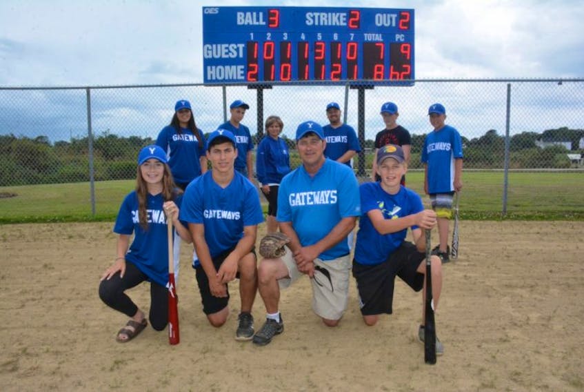 <p>Yarmouth resident Mark Nickerson (second from right first row) and others involved in the local baseball scene, pose for a photo in front of a new electronic scoreboard that’s been installed just beyond centrefield at the Mariners Field in Yarmouth.</p>