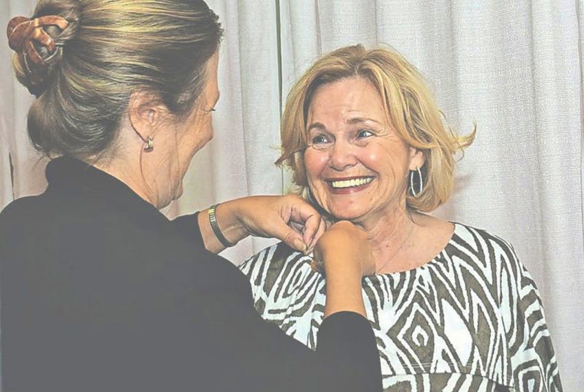 <p>Jane Sharpe, executive director of the Greater Summerside Chamber of Commerce, pins a commemorative pin onto Elizabeth Noonan’s collar. Noonan was recognized with this year’s Paul Harris Fellowship for the Rotary club.&nbsp;</p>
