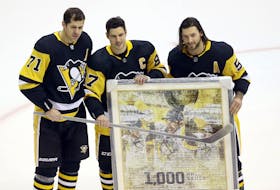 Pittsburgh Penguins centre Evgeni Malkin (71) and defenceman Kris Letang (58) present Sidney Crosby (87) with gifts commemorating his 1,000th career NHL game as a Penguin before playing the New York Islanders at PPG Paints Arena on Saturday. (Charles LeClaire-USA TODAY Sports)
