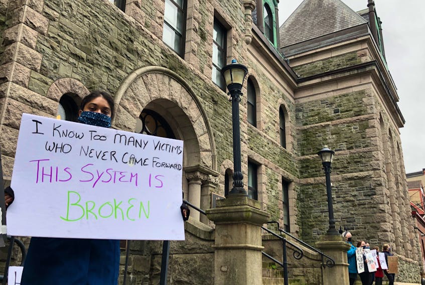 A protester holds a sign outside Newfoundland and Labrador Supreme Court on Duckworth Street in St. John's in early October. The demonstrators called for judicial reform and an end to sexual violence. TELEGRAM FILE PHOTO