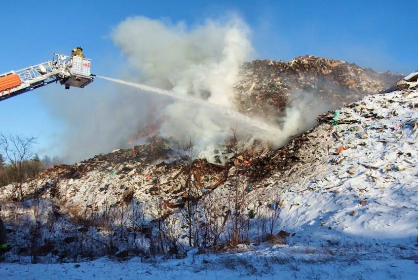 Firefighters used aerial ladders to battle a fire in a large pile of debris at the C&amp;D waste disposal site on North River Road in March 2016.