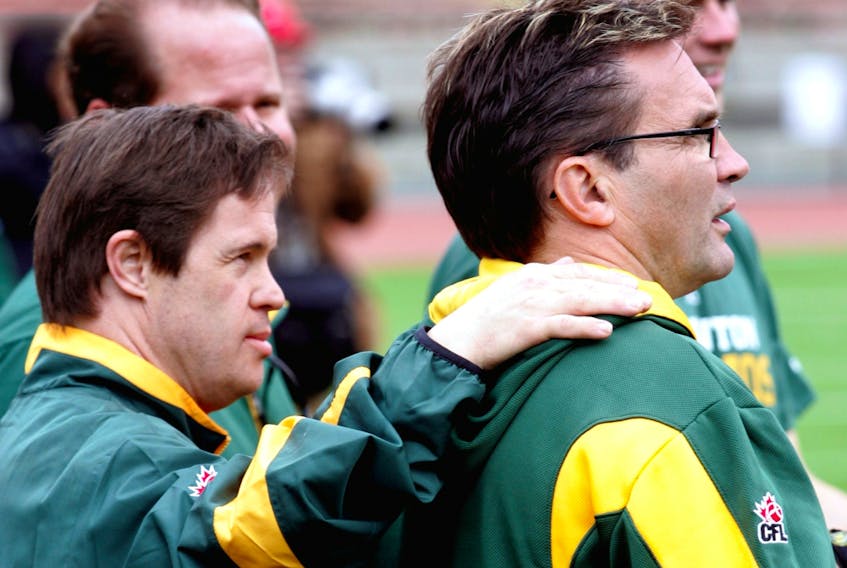 Edmonton Football Club locker-room attendant Joey Moss puts his hand on the shoulder of equipment manager Dwayne Mandrusiak during 2010 training camp at Commonwealth Stadium in this file photo.