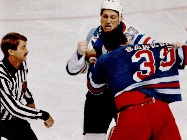Edmonton Oilers tough guy Marty McSorley punches it out with New York Rangers Terry Carkner as NHL linesman Swede Knox stands by in 1987 at Northlands Coliseum in Edmonton.