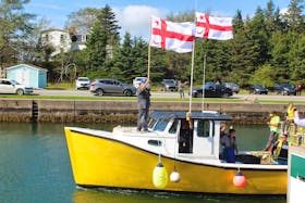 One of the moderate livelihood fishing boats heading out into the St. Peter's Canal in this October 2020 file photo. The boat is flying Mi'kmaq grand council flags as the driver of the boat holds up the tags issued by Potlotek First Nation. CAPE BRETON POST FILE