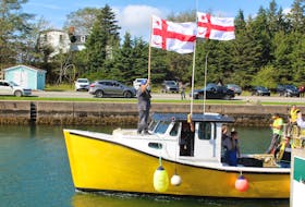 One of the moderate livelihood fishing boats heading out into the St. Peter's Canal in this October 2020 file photo. The boat is flying Mi'kmaq grand council flags as the driver of the boat holds up the tags issued by Potlotek First Nation. CAPE BRETON POST FILE