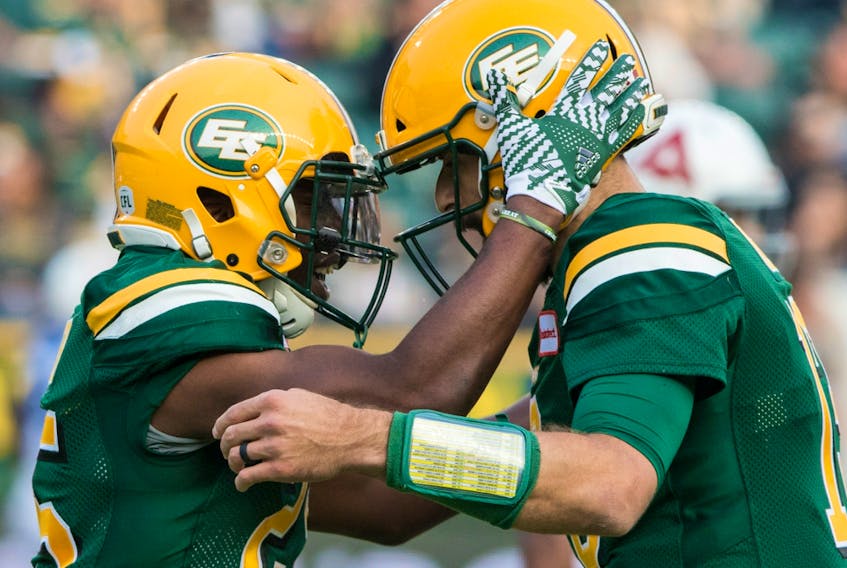 Edmonton Football Team running back Shaquille Cooper (25) celebrates his touchdown against the Montreal Alouettes with quarterback Mike Reilly (13) in this file photo from August 18, 2018, in Edmonton.