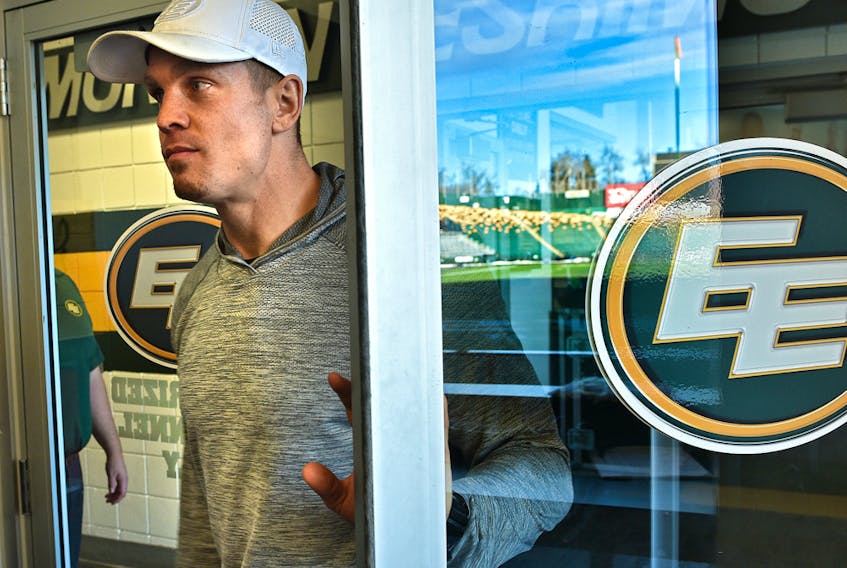 Eskimos quarterback Trevor Harris opens a door with Commonwealth Stadium reflected off the glass, on his way to speak to the media at the end of the CFL season on Nov. 18, 2019.