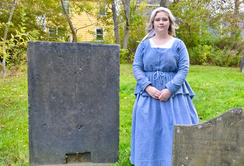 Old Sydney Society tour guide Kate Devoe stands next to the gravestone of Capt. John Butler Wilson, who built the original St. Patrick’s Church Chapel in Sydney. Wilson’s body isn’t buried there — he remains under the church itself with several other people, although his headstone was moved outside the church. 
ELIZABETH PATTERSON/CAPE BRETON POST