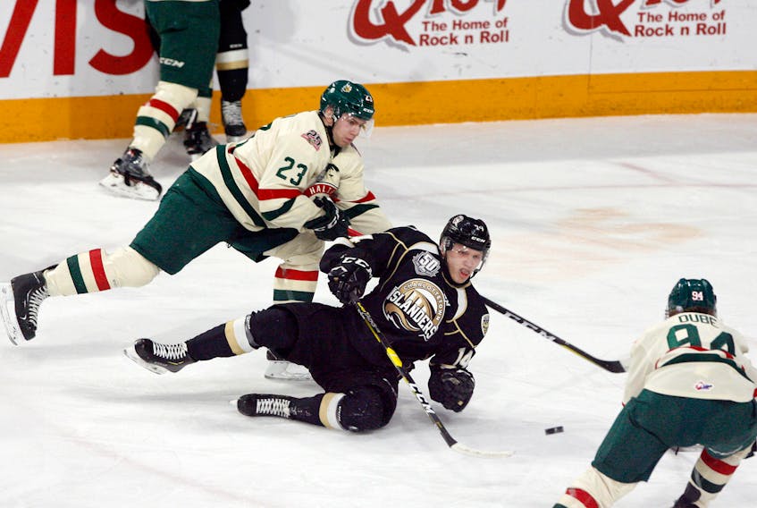 Charlottetown Islanders centre Nikita Alexandrov trips up after fighting for the puck with Halifax Mooseheads centre Keith Getson, a former Islanders forward, in the Halifax end during first period action Wednesday.