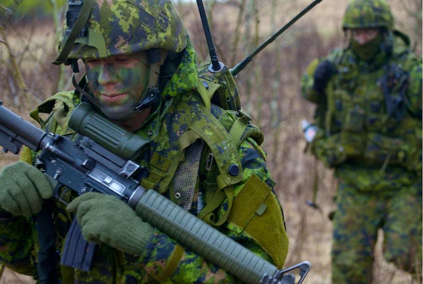 Canadian soldiers conduct dismounted patrols in a training area.
