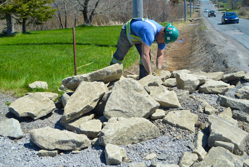 Nelson Bennett, an employee with Municipal Ready Mix in Sydney River, works on building a rock wall at a culvert near the Radar Base on Lingan Road. Major roadwork is underway on Lingan Road including ditching and culvert work, as well as paving. Sharon Montgomery-Dupe/Cape Breton Post