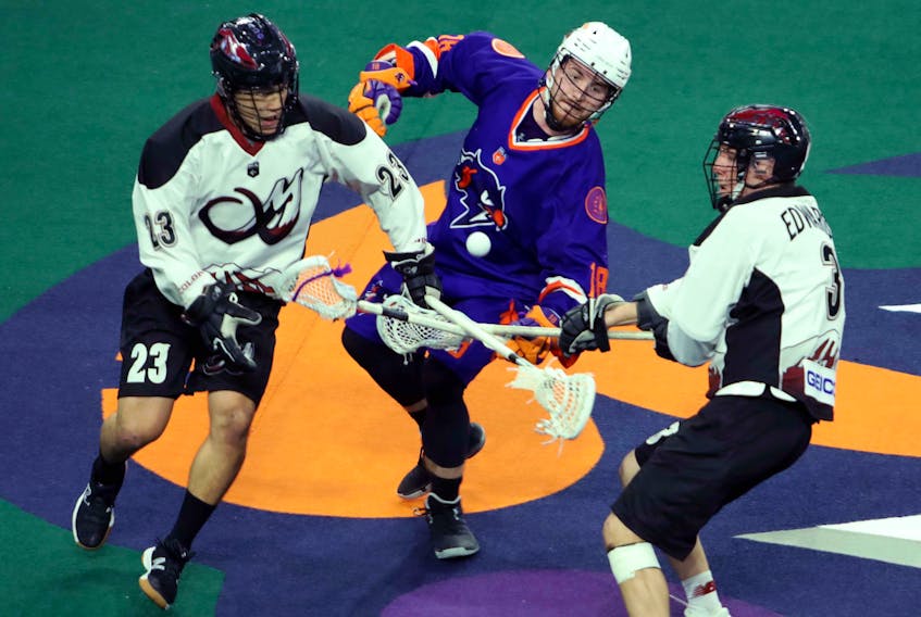 Halifax Thunderbirds’ Jake Withers, centre, battles Jordan Gilles, left, and Tim Edwards of the Colorado Mammoth for a loose ball during a Jan. 11 NLL game at the Scotiabank Centre. (ERIC WYNNE/Chronicle Herald)