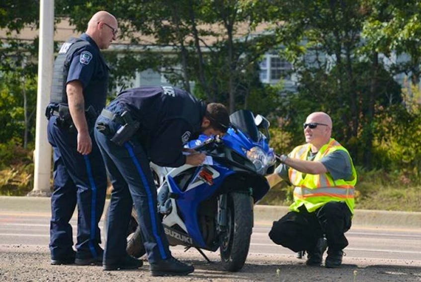 FILE PHOTO: Members of Charlottetown Police Services check over a motorcycle involved in a fatal accident on the bypass highway Tuesday. A man driving the bike was killed and his female passenger taken to hospital after the crash, which occurred about 11 a.m.
