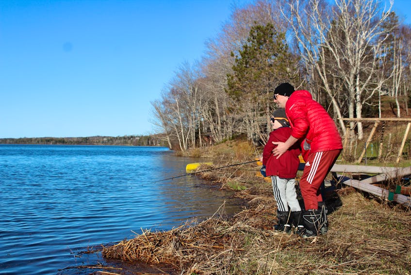 Six-year-old Henry Crnic and his father Jason watch to see how far Henry's cast went while fishing off a shore along Blacketts Lake at 7:30 a.m. on Sunday. Jason, who moved to Nova Scotia from Ontario after receiving a scholarship to play soccer for Cape Breton University, said he and Henry caught a large pickerel last summer while fishing along the same shore. Like many Nova Scotians, Jason and Henry are glad the provincial government has lifted the restrictions on fishing while the stay-at-home orders to stop the spread of COVID-19 are still in place. NICOLE SULLIVAN/CAPE BRETON POST 