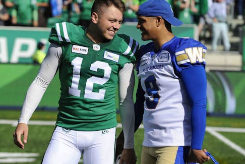 Winnipeg Blue Bombers kicker Justin Medlock, right, congratulates Brett Lauther after the Roughriders' kicker made a game-winning field goal in the Labour Day Classic on Sept. 1. 