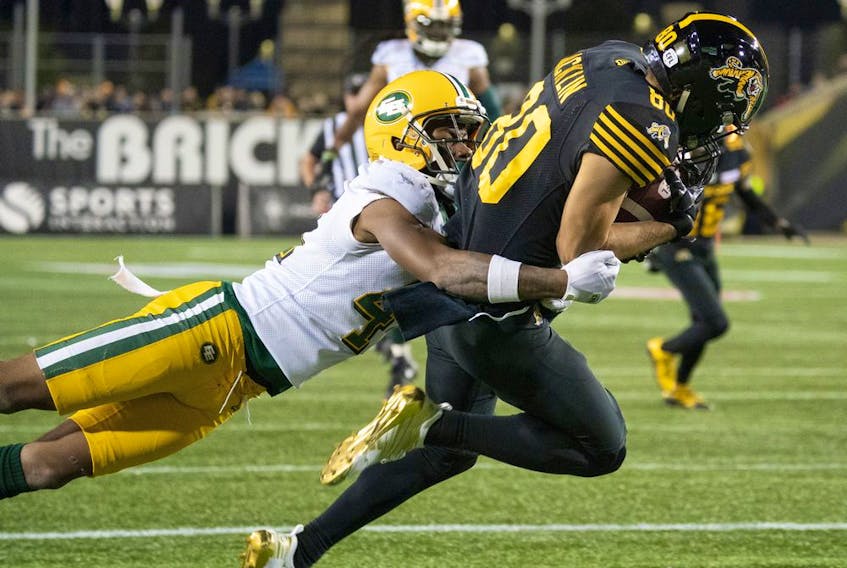 Hamilton Tiger-Cats wide receiver Jaelon Acklin (80) is tackled by Edmonton Eskimos defensive back Monshadrik Hunter (41) during first half CFL football game action in Hamilton, Ont., Friday, Oct. 4, 2019.