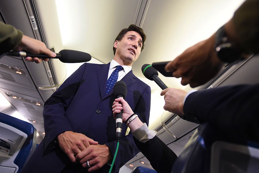 Liberal Leader Justin Trudeau responds to a question after making a statement in regards to photo coming to light of himself from 2001 wearing "brownface" during a scrum on his campaign plane in Halifax, N.S., on Sept. 18, 2019.