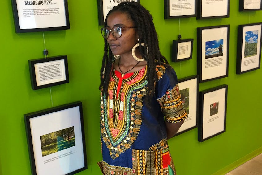 Praise Mugisho in front of the exhibit called Picturing Recreation at the Halifax Central Library on Wednesday, Sept. 25, 2019. Mugisho is one of the newcomers who submitted photos that show personal definitions of recreation.
