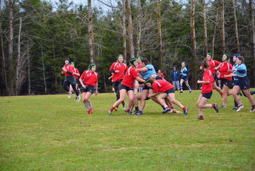 Members of the Charlottetown Rural Raiders, red jerseys, tackle a member of North Nova Educational Centre during first-half action in the girls’ championship game of the 23rd annual David Voye Memorial rugby tournament at Three Oaks Senior High School in Summerside on Saturday afternoon. The Raiders won the exciting final 21-19.