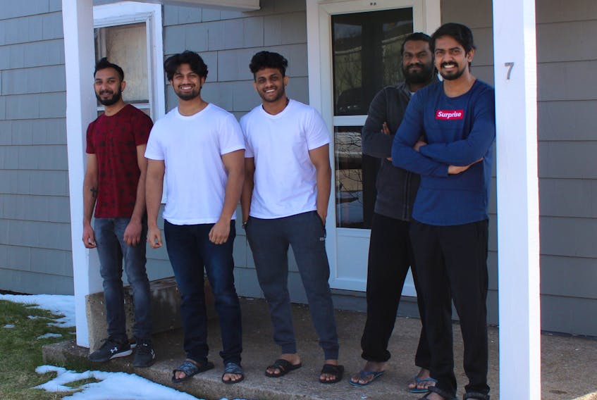 From left, Alwin Biju Kuriakose, Sarin Sasidharan, Rahul Radhakrishnan, Aswin Pariyaran and Ashif Abdul Azeez stand on the front step of the house they are renting in Sydney, which they moved into a week after a fire at 413 Charlotte Street in March lead to the demolition of their apartment building. Many of the men, who are from Kerala, India, and came to Nova Scotia to study at Cape Breton University, had recently been laid off from their jobs before the fire due to businesses closing or downsizing staff while the health protection orders are in place to stop the spread of COVID-19. NICOLE SULLIVAN/CAPE BRETON POST 
