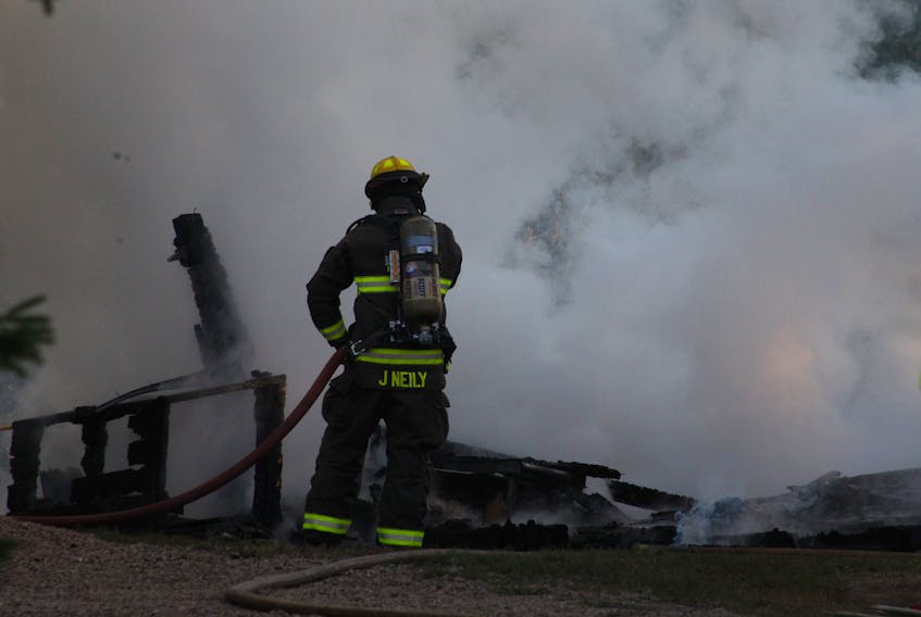 A firefighter aims a hose at what remains of a garage that was on fire, and called in just before 7 p.m. Sept. 8.