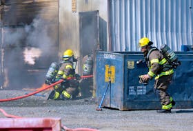 Firefighters with the St. John’s Regional Fire Department make their way into a storage depot on Sugarloaf Road where a fire was reported Monday. Keith Gosse/The Telegram