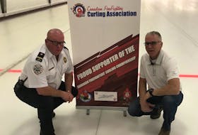 Winston Bryan, left, and Peter MacDonald, co-chairmen of the upcoming Canadian FireFighters Curling Championships in Charlottetown, display signage and tournament logo for the event scheduled for March 26-April 4. The Charlottetown Curling Complex will host the 12-team national event.