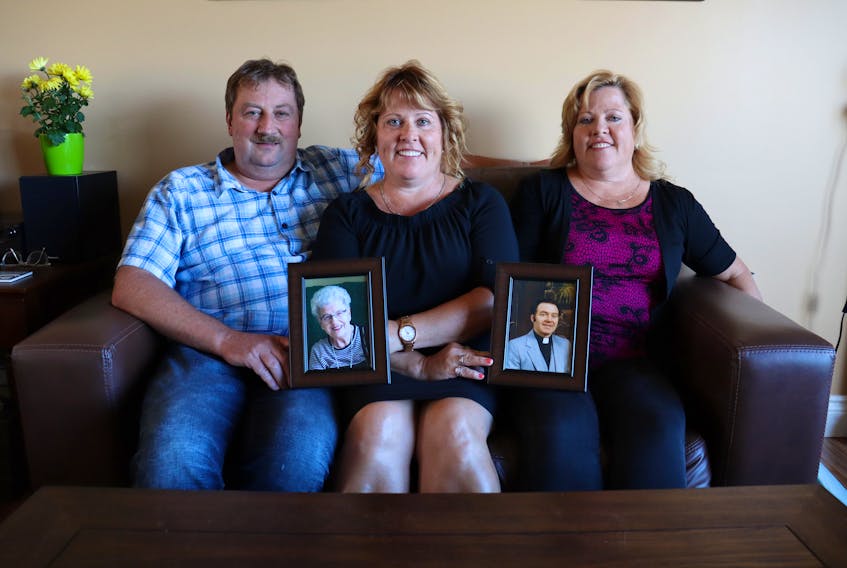 Multiple myeloma patient Dwight Gardiner, left, his wife, Megan, and her sister, Bethany Reeves, hold photos of family members who have died from multiple myeloma. In the photos are Dwight's aunt, Lorna Cairns, and the women’s father, Wilfred Wagner.