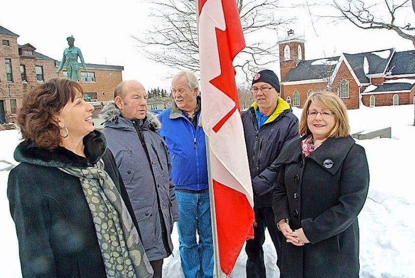 Katherine Hatheway, Coun. Terry Rhindress, YMCA Peace Medal recipients Paul Calder (on behalf of the Amherst Rotary Refugee Project) and Ken MacKenzie and Deputy Mayor Sheila Christie raise the flag in Victoria Square to mark National Flag Day of Canada on Wednesday.
