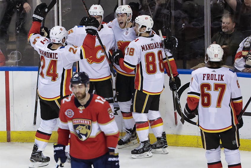 Calgary Flames center Mark Jankowski, center, celebrates with teammates after scoring agains the Florida Panthers during the third period of an NHL hockey game Thursday, Feb. 14, 2019, in Sunrise, Fla. (AP Photo/Brynn Anderson) ORG XMIT: FLBA124
