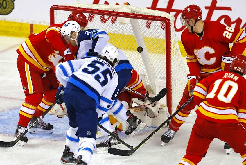 Calgary Flames goalie Jacob Markstrom is scored on by the Winnipeg Jets’ Mark Scheifele at the Scotiabank Saddledome in Calgary on Monday, March 29, 2021. 