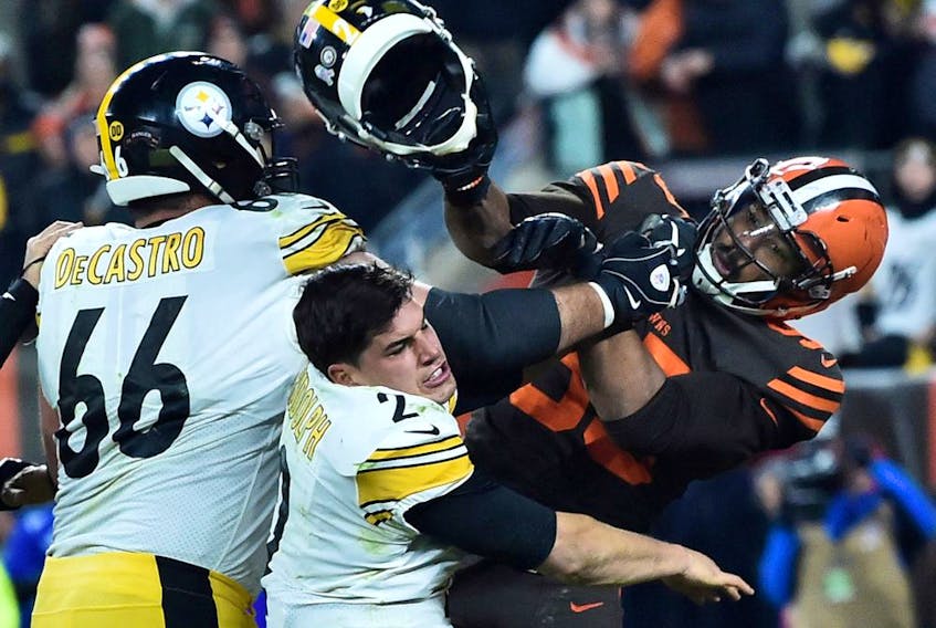 Cleveland Browns defensive end Myles Garrett hits Pittsburgh Steelers quarterback Mason Rudolph with his own helmet as offensive guard David DeCastro tries to stop Garrett during the fourth quarter at FirstEnergy Stadium. 
