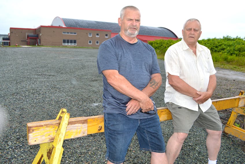 Wayne Perry, 67, left, and Frank Wadden, 70, long-time icemakers at the Bayplex in Glace Bay, stand near the facility that’s been closed more than three years. The men say they will do whatever it takes to get their jobs back. Sharon Montgomery-Dupe/Cape Breton Post