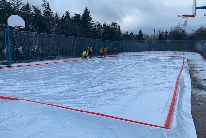 City of Mount Pearl public works staff work on constructing an outdoor skating rink at the basketball courts off Murley Drive last week. It's one of four outdoor rinks the city will have available for public use this winter. — CONTRIBUTED