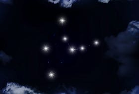 The constellation VIrgo is seen through the clouds in the night sky. 
