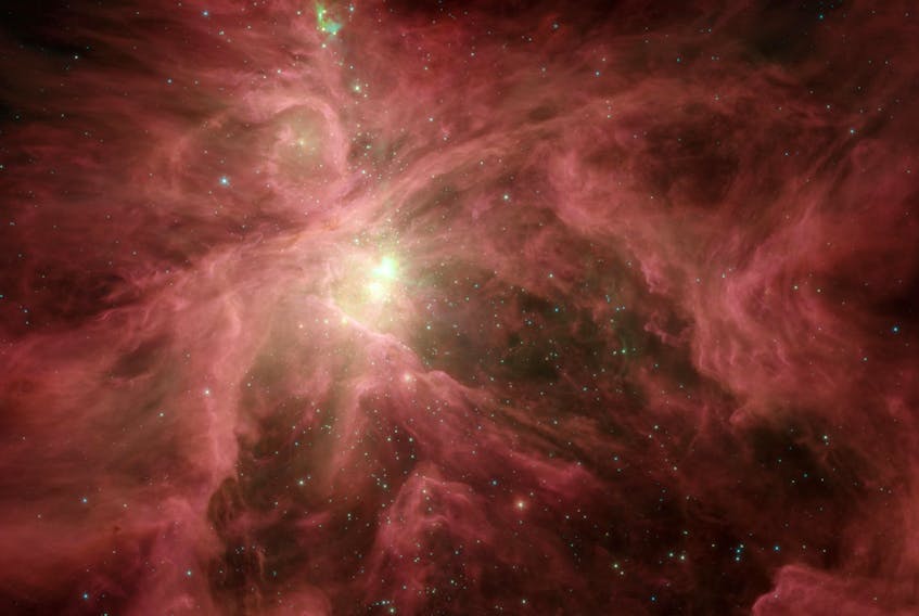This image from NASA Spitzer Space Telescope shows the Orion nebula, our closest massive star-making factory, 1,450 lightyears from Earth. The nebula is close enough to appear to the naked eye as a fuzzy star in the sword of the constellation. - NASA