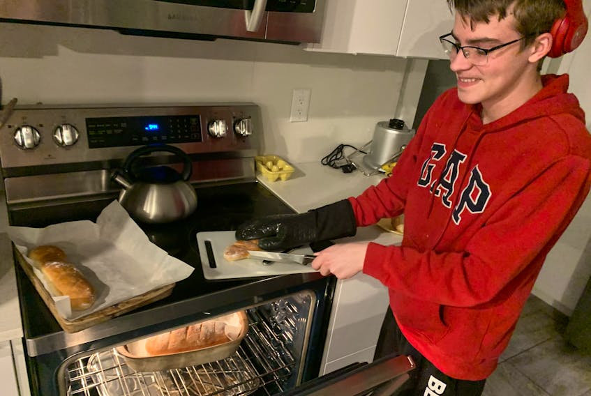 Zain Guthrie, 15, is learning to make all sorts of bread from scratch from his father. Scott Guthrie remembers learning to make bread with his grandmother and says it is time to pass the experience along to his son. 