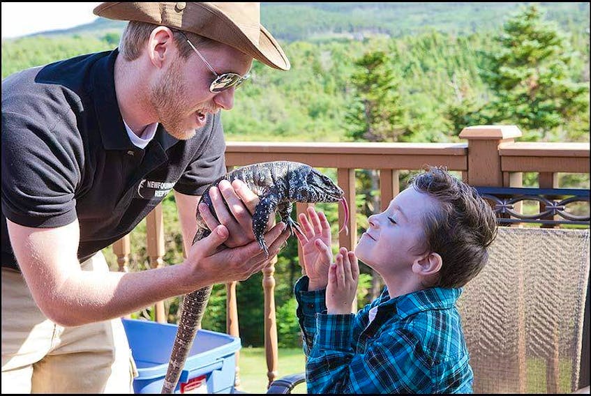 Jelly Bean Entertainment owner Troy Stuckless, from St. John’s, introduces Nixon Marsh to one of his reptiles. Stuckless has owned reptiles for 17 years and, for the past decade, has offered reptile education shows.