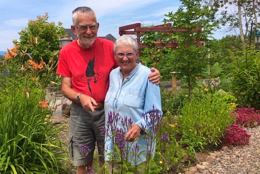 Carole Donaldson and Howard Williams of Wolfville, N.S. stand in their colourful backyard garden, which is composed of native plants.