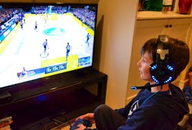 Jack Bell plays a video game at home. Try building time on screens into your daily schedule.