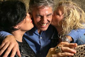 Columnist Emilie Chiasson, left, and a friend enjoy a shared smooch with “Ricardo Gere” at a Fado show in Porto, Portugal. 