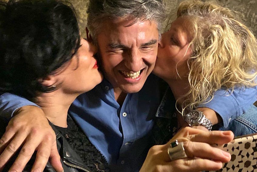 Columnist Emilie Chiasson, left, and a friend enjoy a shared smooch with “Ricardo Gere” at a Fado show in Porto, Portugal. 